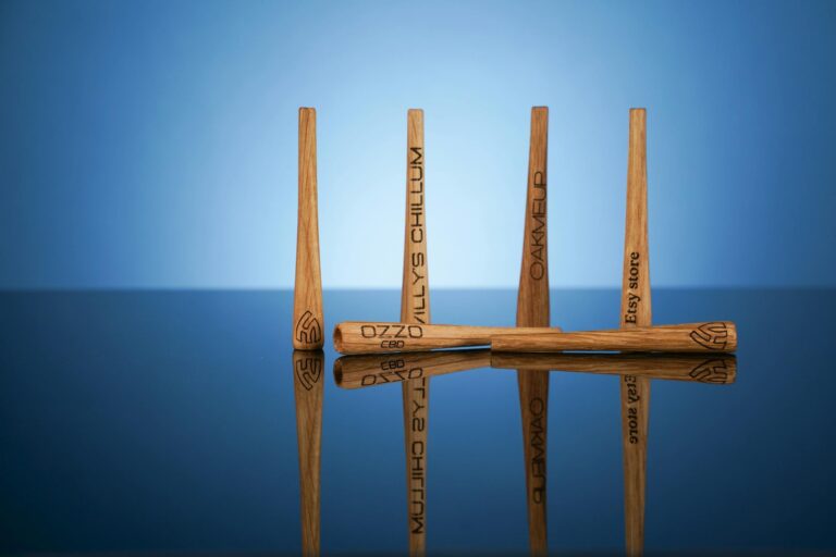 Close-up of engraved wooden sticks with reflections on a glossy surface, ideal for product design visuals.