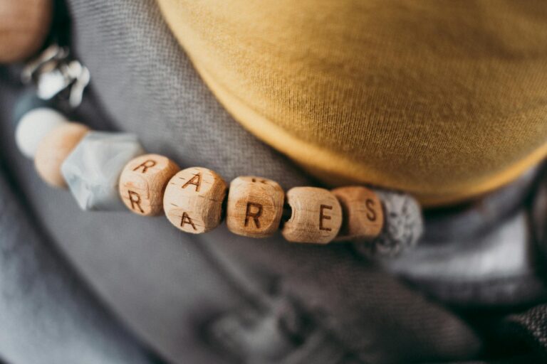 Detailed view of a wooden bead bracelet spelling 'RARES' with selective focus highlighting craftsmanship.