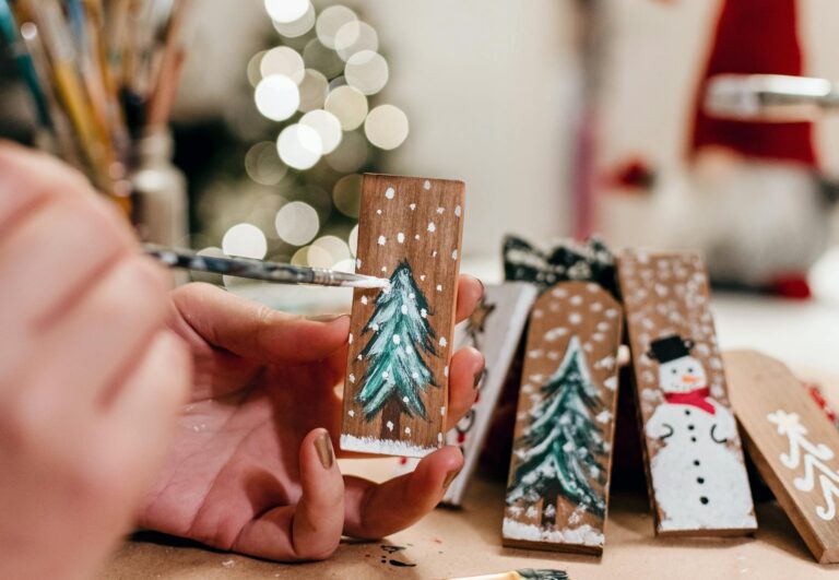Hand painting wooden Christmas decorations with festive themes. Perfect for holiday crafting.